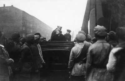 Arbeitemenge vor Kutsche in der Clara Zetkin sitzt